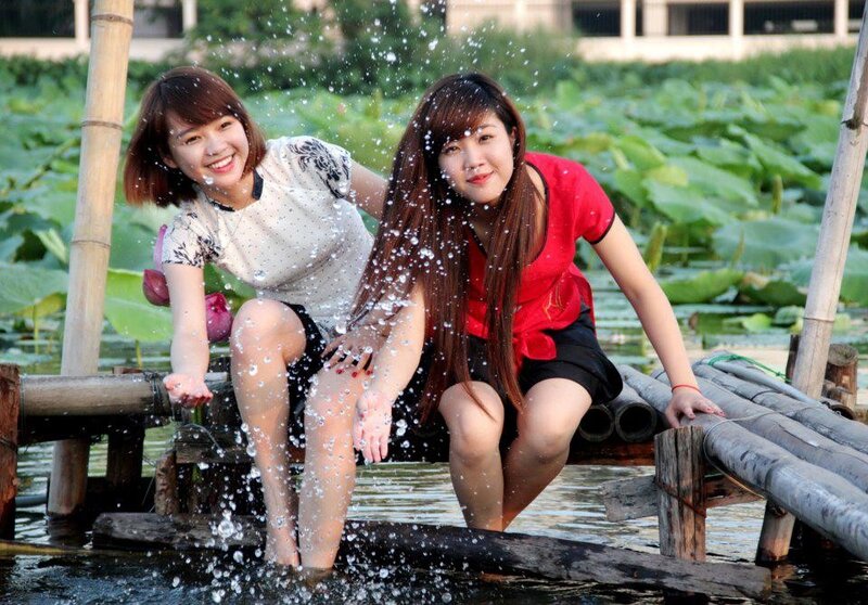 Two women splashing water on a dock