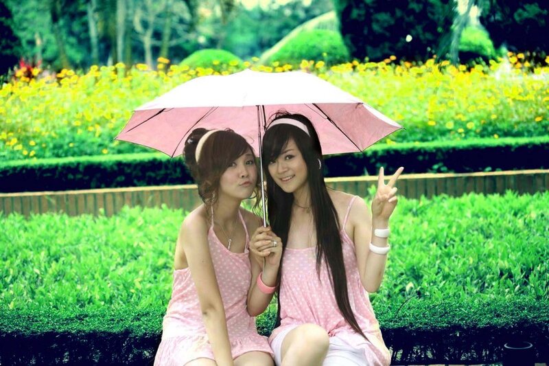 Two women under a pink umbrella