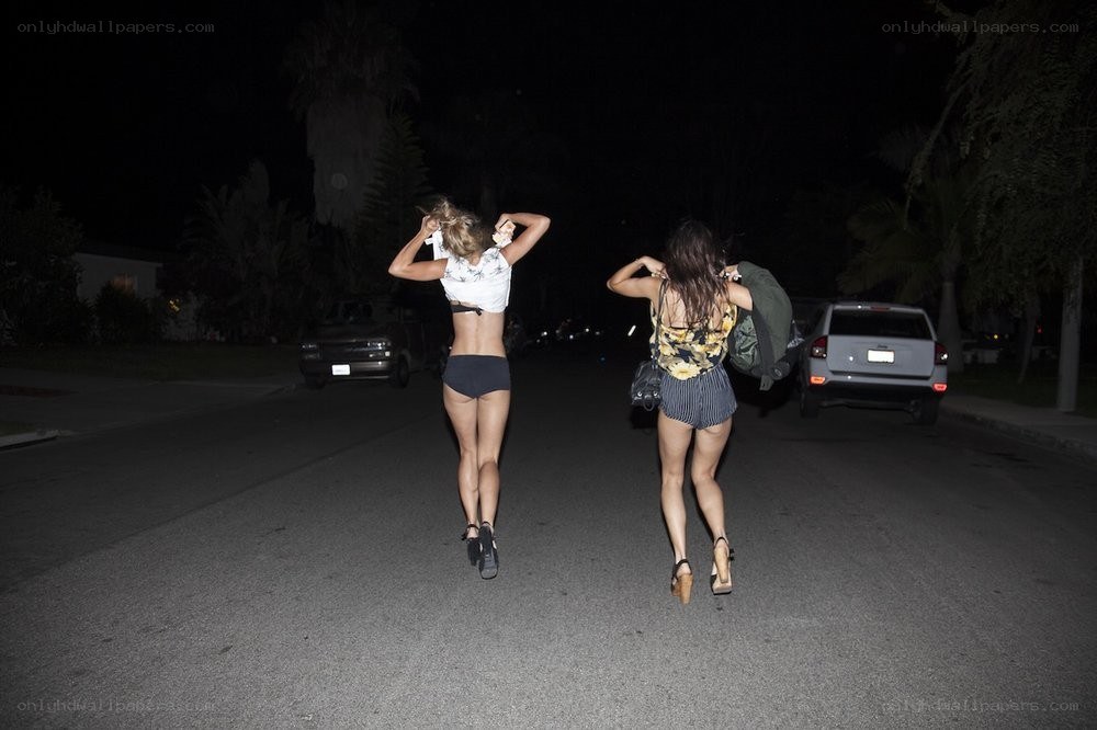 Two women walking at night