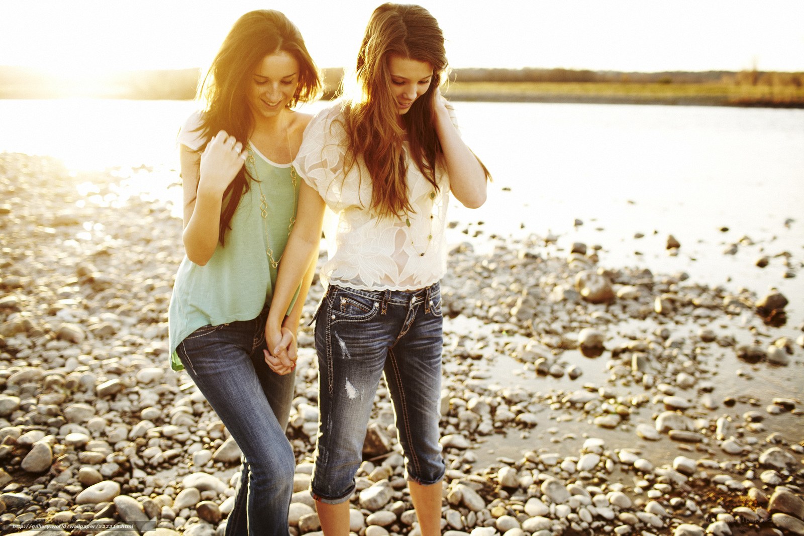 Two women walking on a pebble beach
