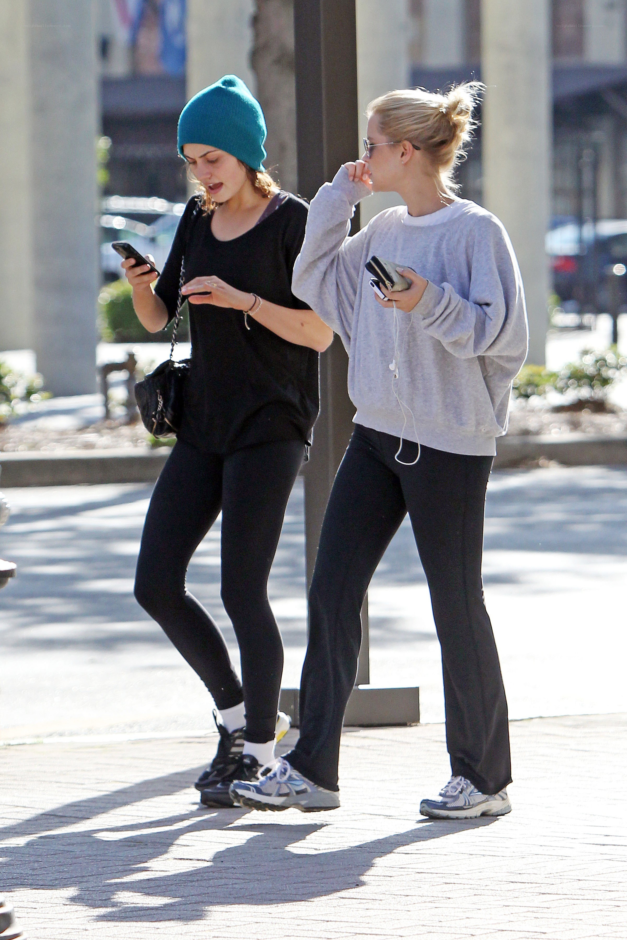 Two women walking on a sidewalk