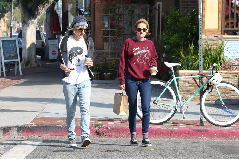 Two women walking on a sidewalk