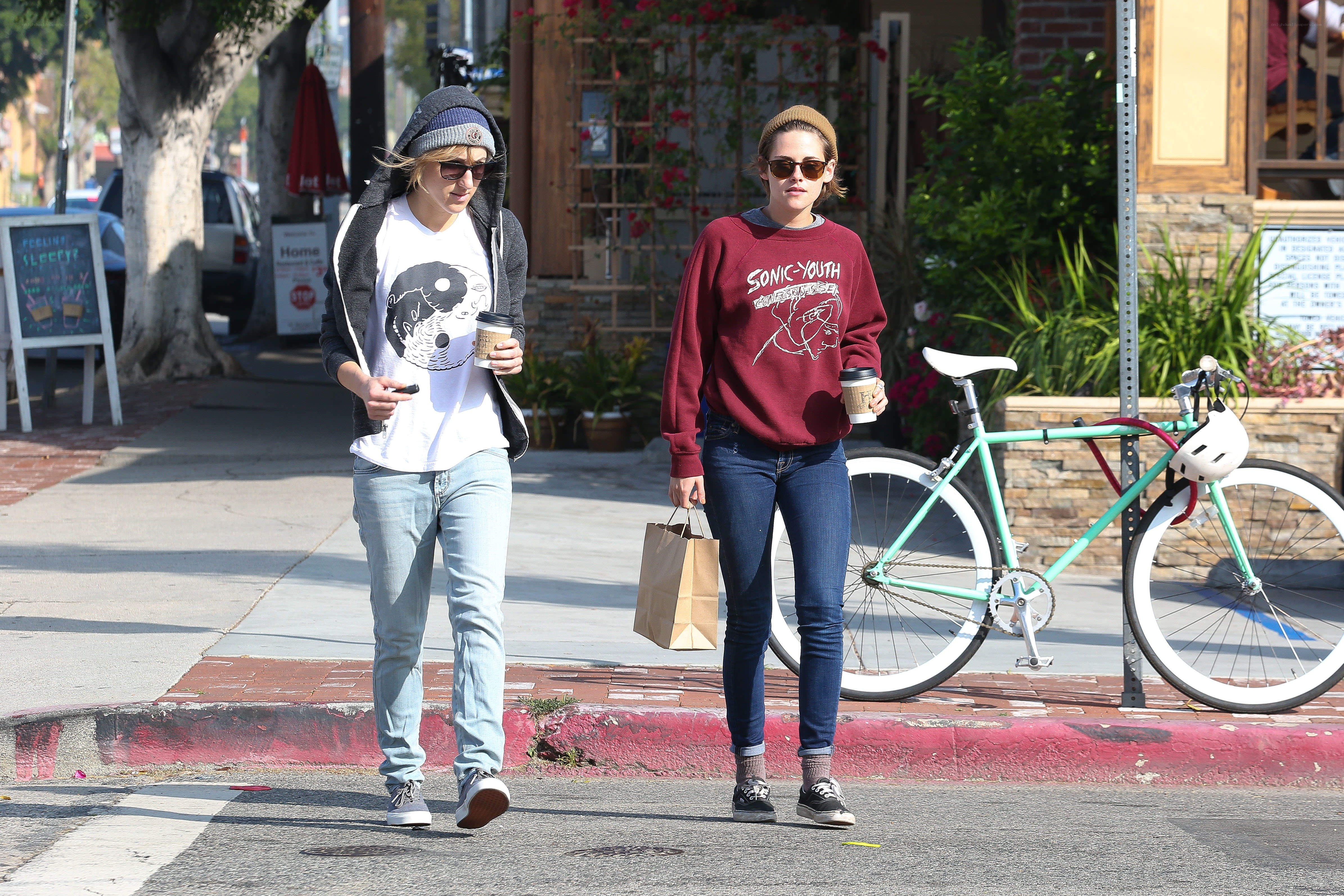 Two women walking on a sidewalk