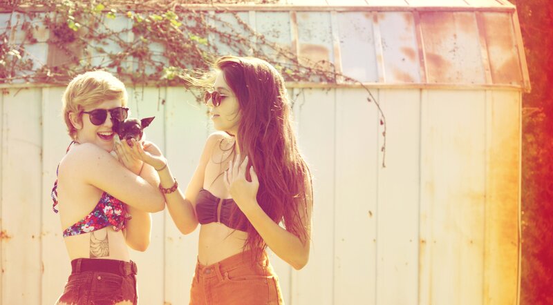 Two women with a dog in sunlight