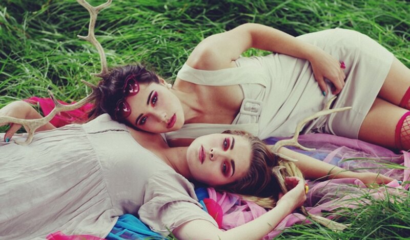 Two women with antlers in grass