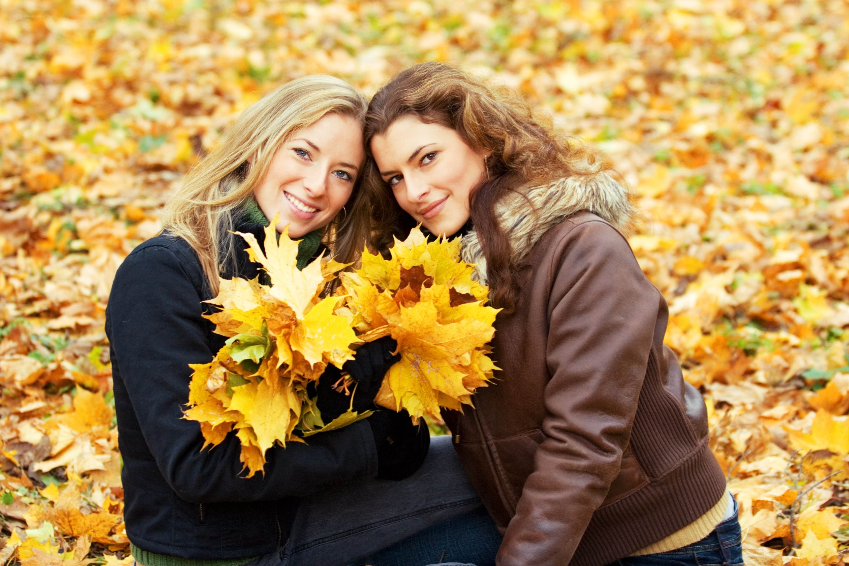 Two women with autumn leaves