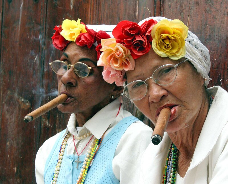 Two women with cigars and flower crowns