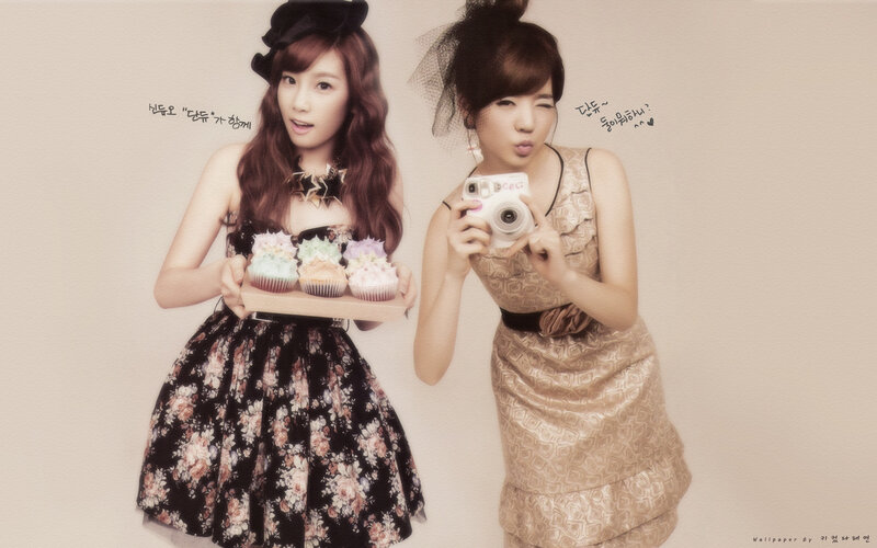 Two women with cupcakes and camera