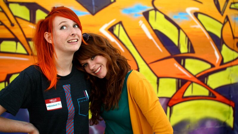 Two women with red hair in front of graffiti