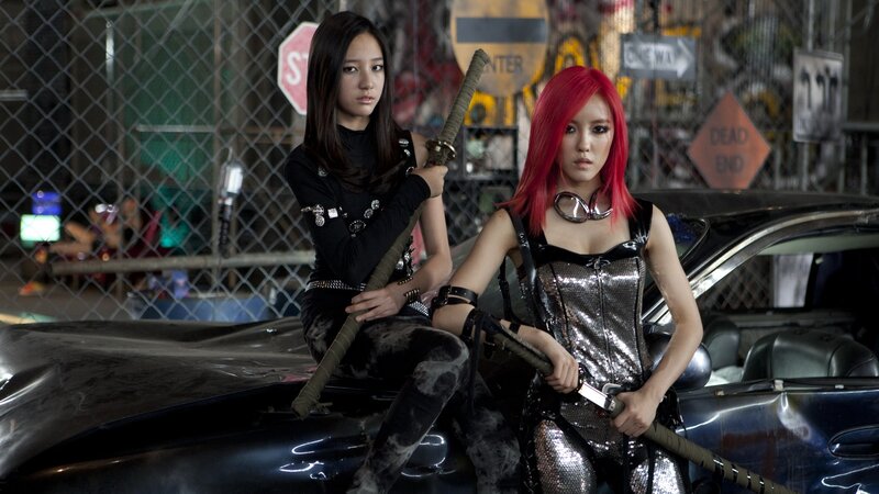 Two women with swords on a car