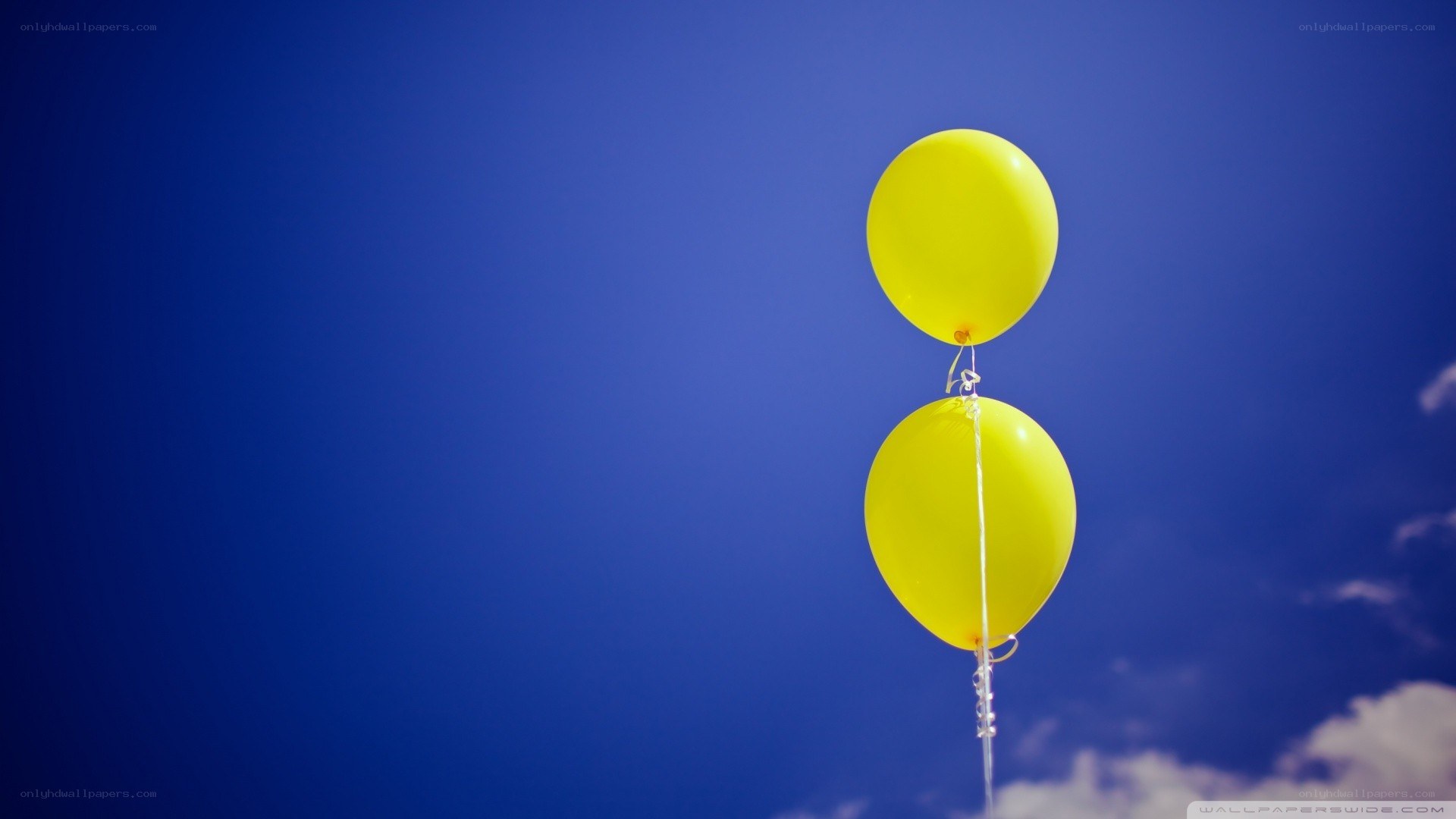 Two yellow balloons in the sky