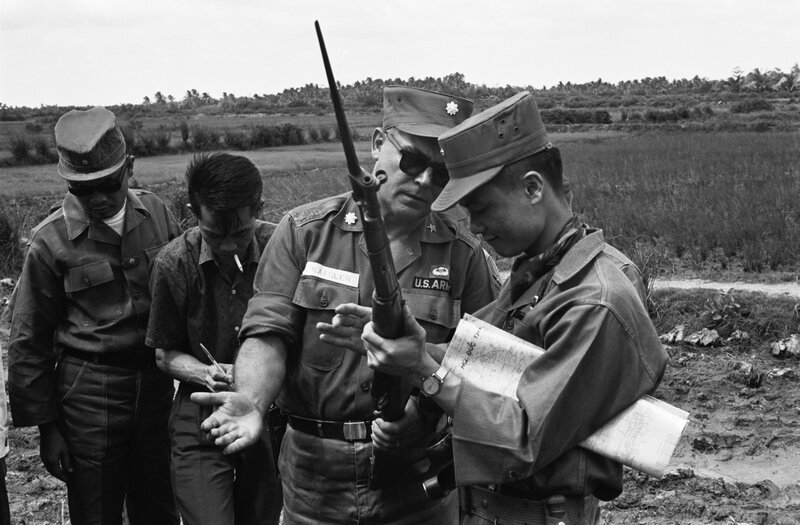U.S. and South Vietnamese officers inspecting a rifle