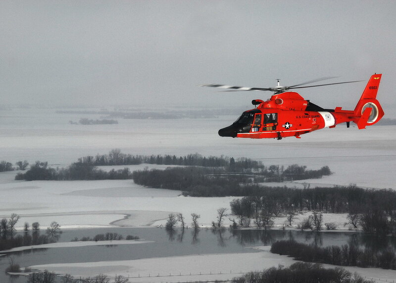 U.S. Coast Guard helicopter over snowy landscape