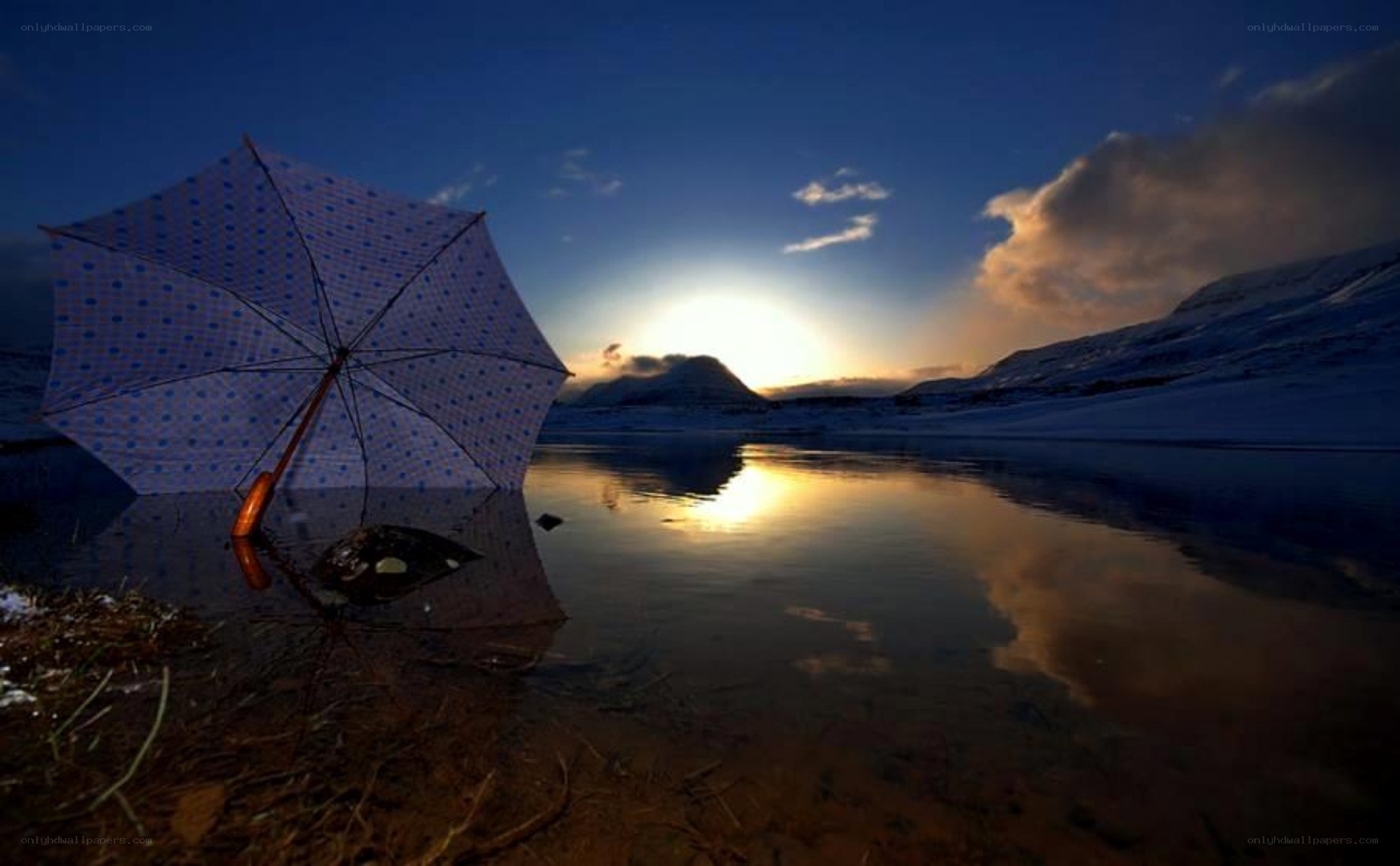 Umbrella by a lake at sunset