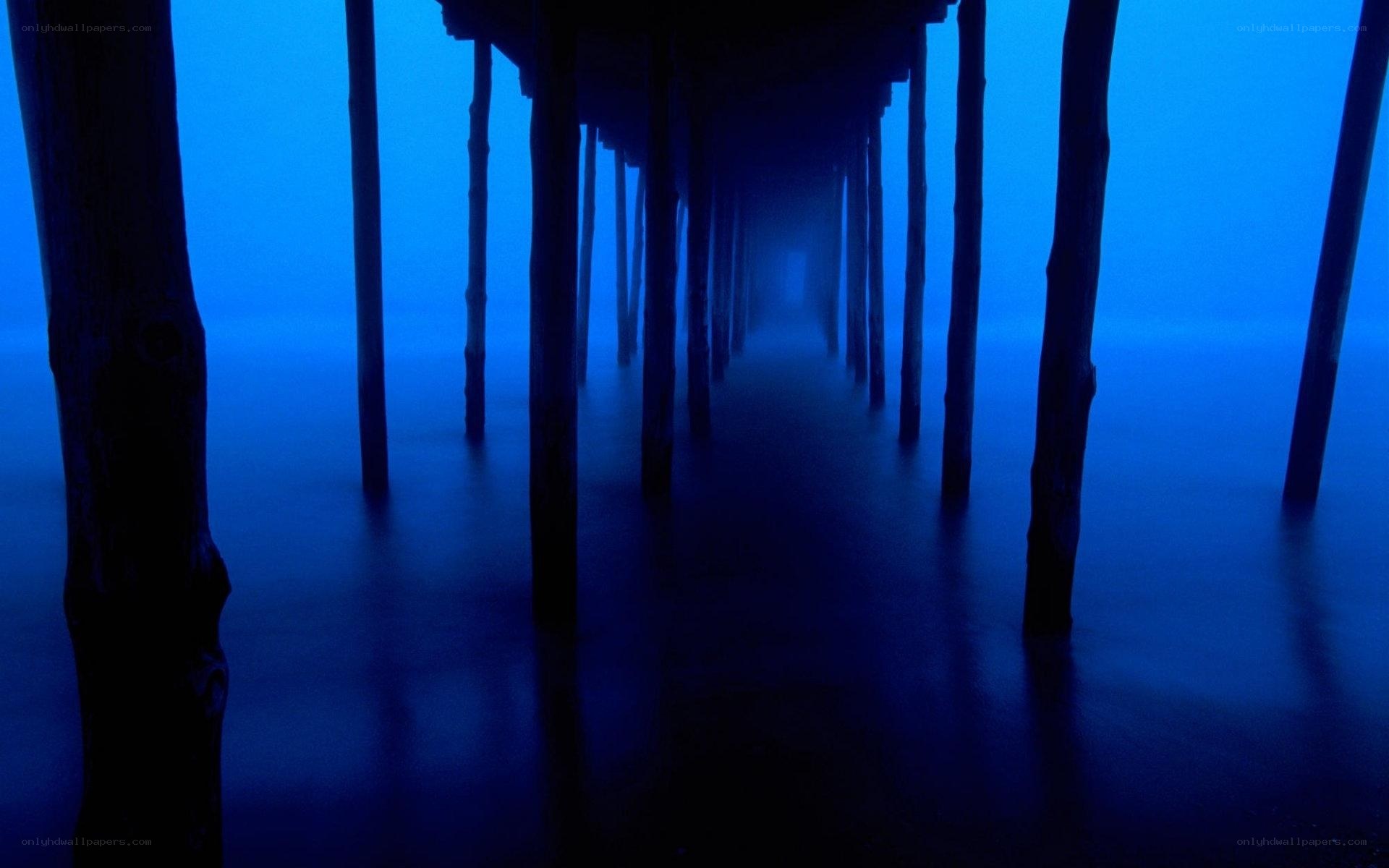 under pier in blue fog