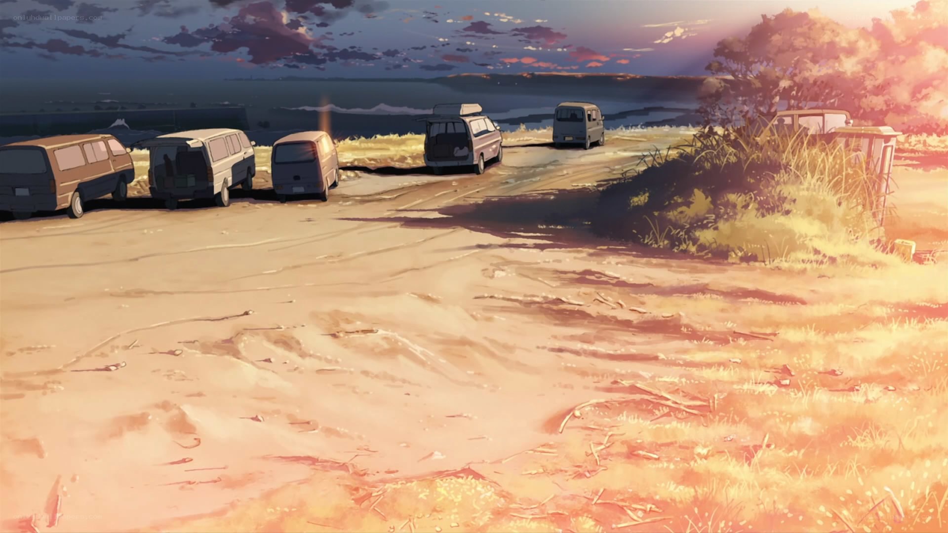 Vans on a coastal road at sunset