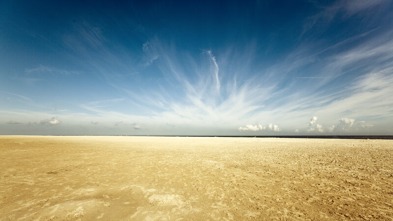 Vast beach under blue sky