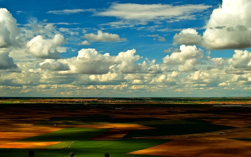 Vast fields under a cloudy sky
