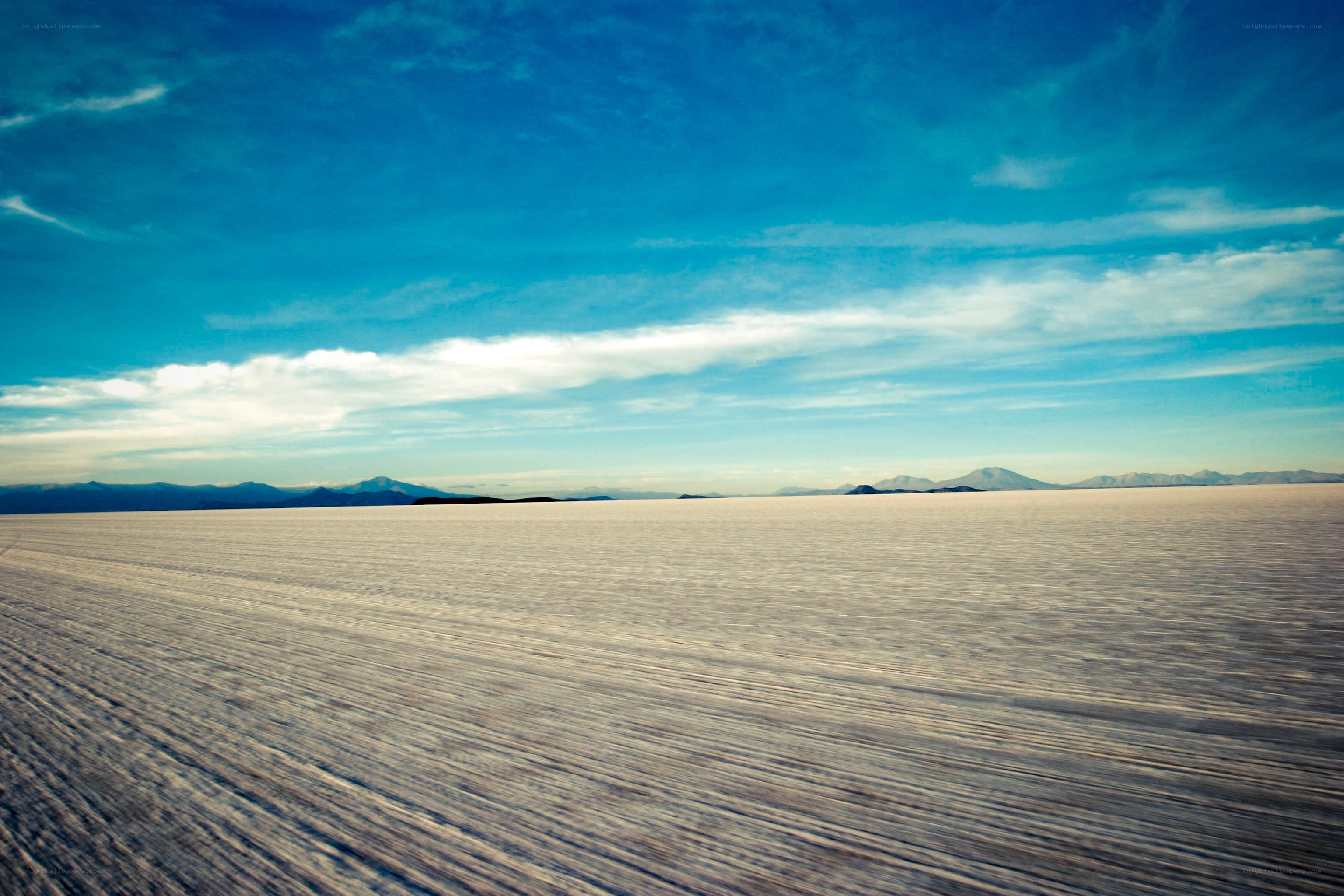 Vast salt flat under blue sky