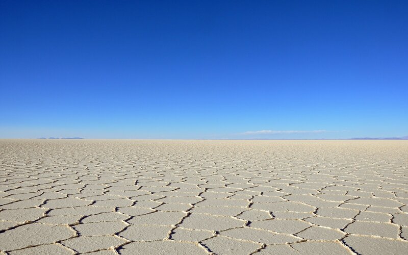 Vast salt flat under blue sky