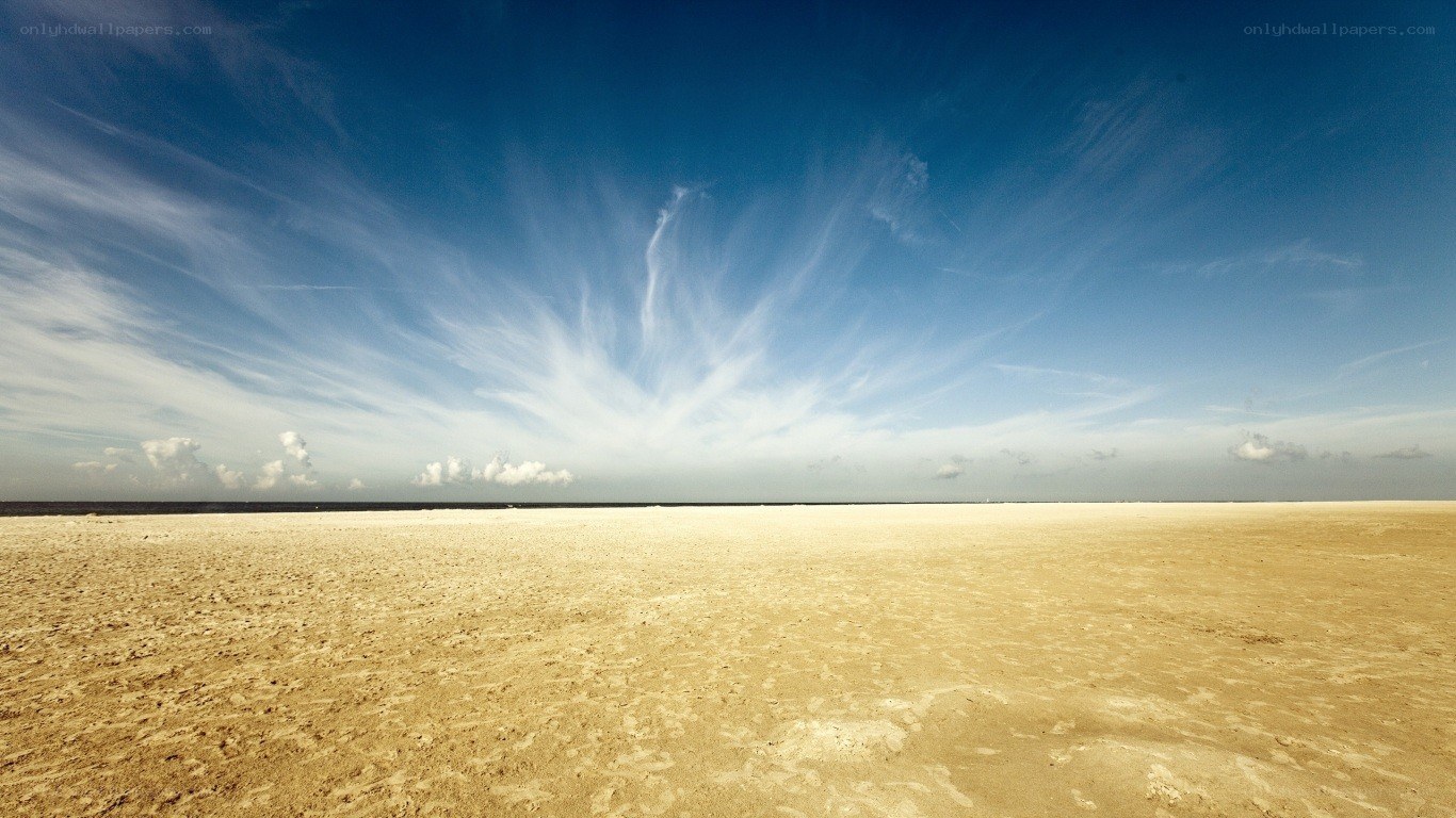 Vast sandy beach under blue sky