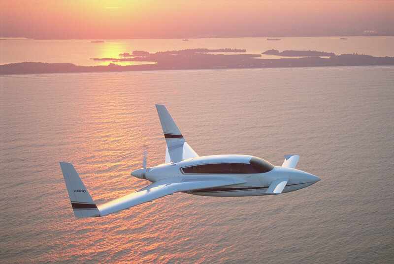 Velocity aircraft over water at sunset
