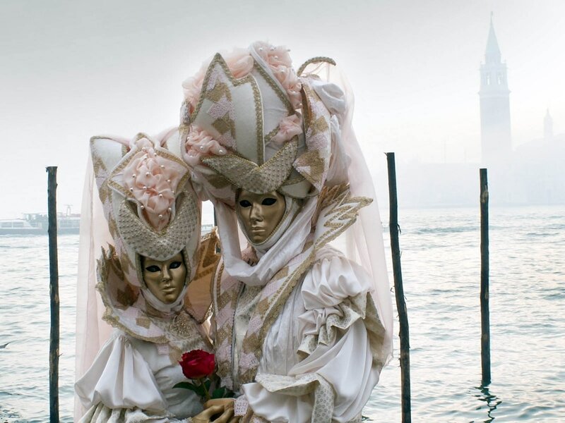 Venetian carnival masks by water