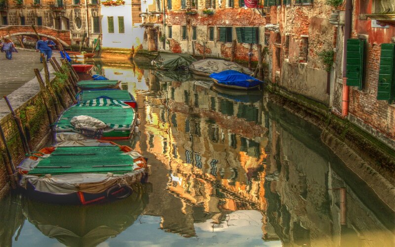 Venice canal with boats and reflections