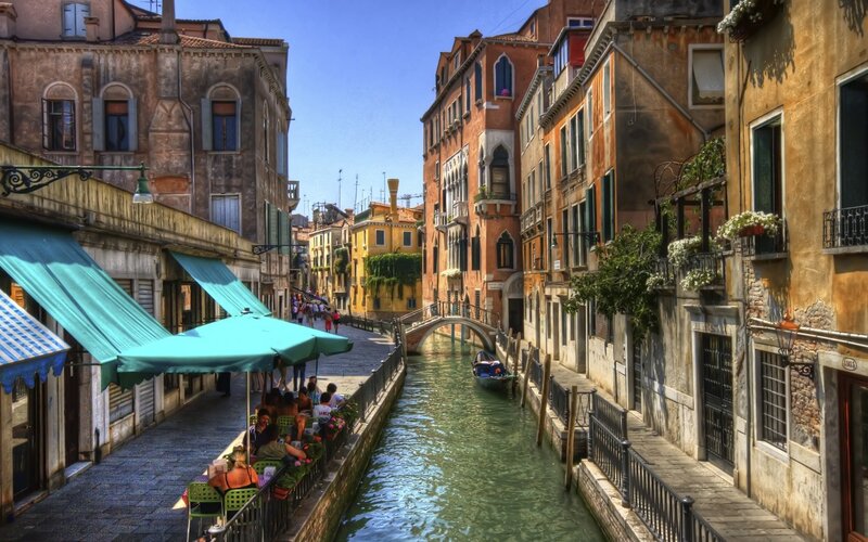 Venice canal with gondola and cafes