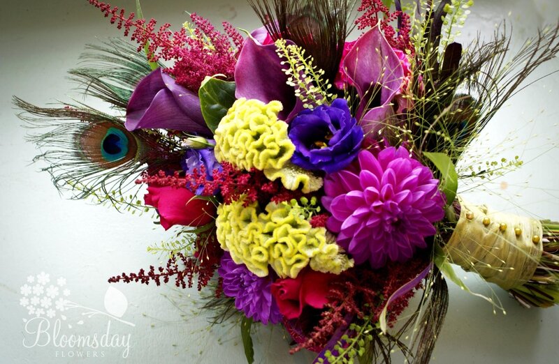 vibrant floral bouquet with peacock feathers