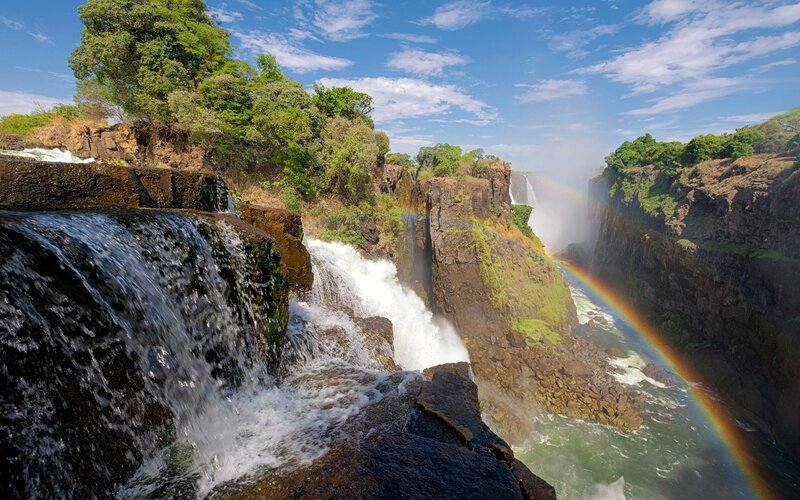 Vibrant rainbow over waterfall