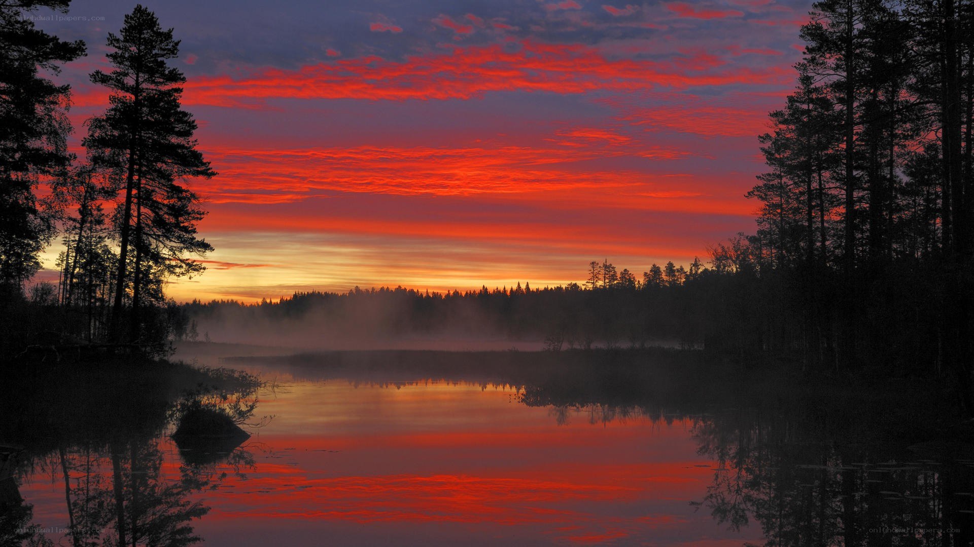 Vibrant sunset over a misty lake
