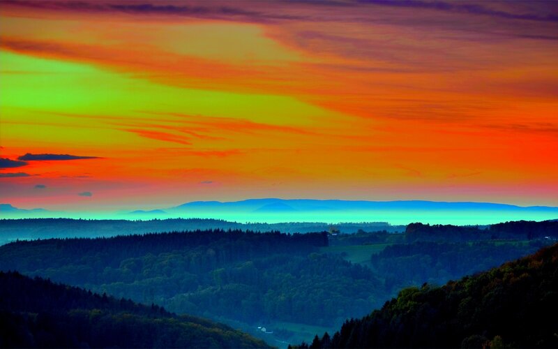 Vibrant sunset over forested hills