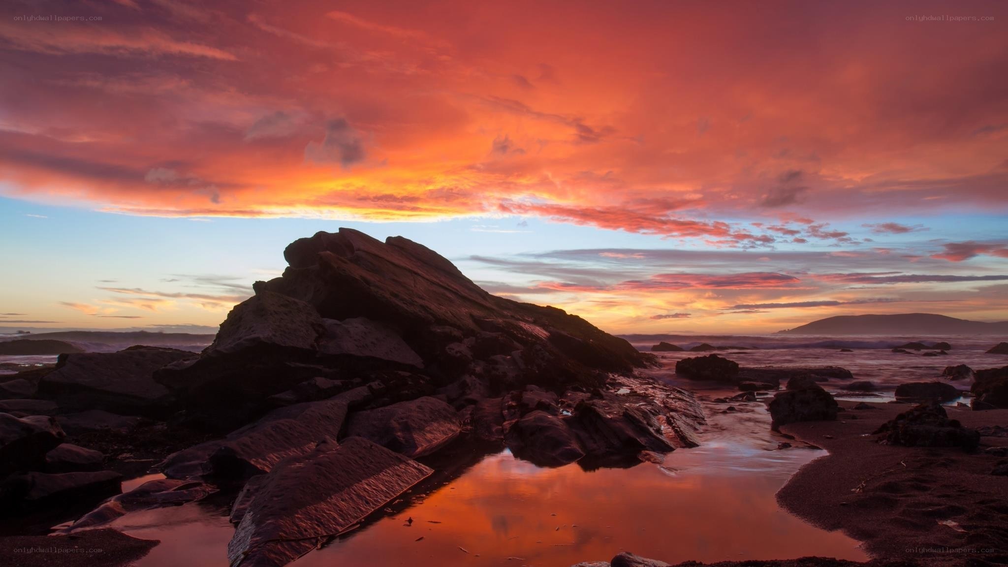 Vibrant sunset over rocky beach