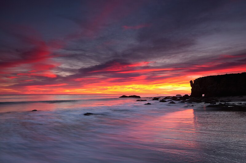 Vibrant sunset over rocky beach