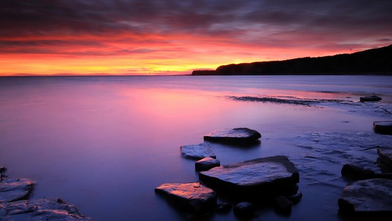 vibrant sunset over rocky shore