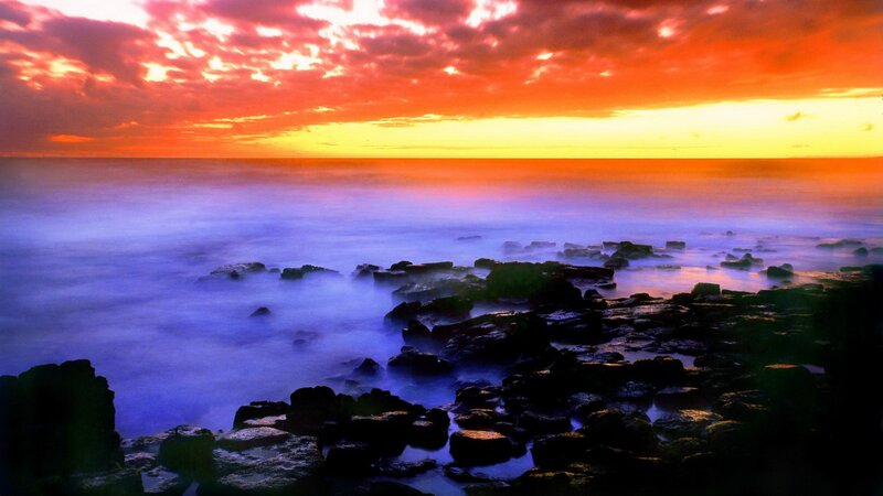 vibrant sunset over rocky shore