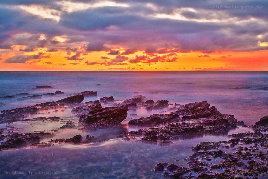 Vibrant sunset over rocky shore