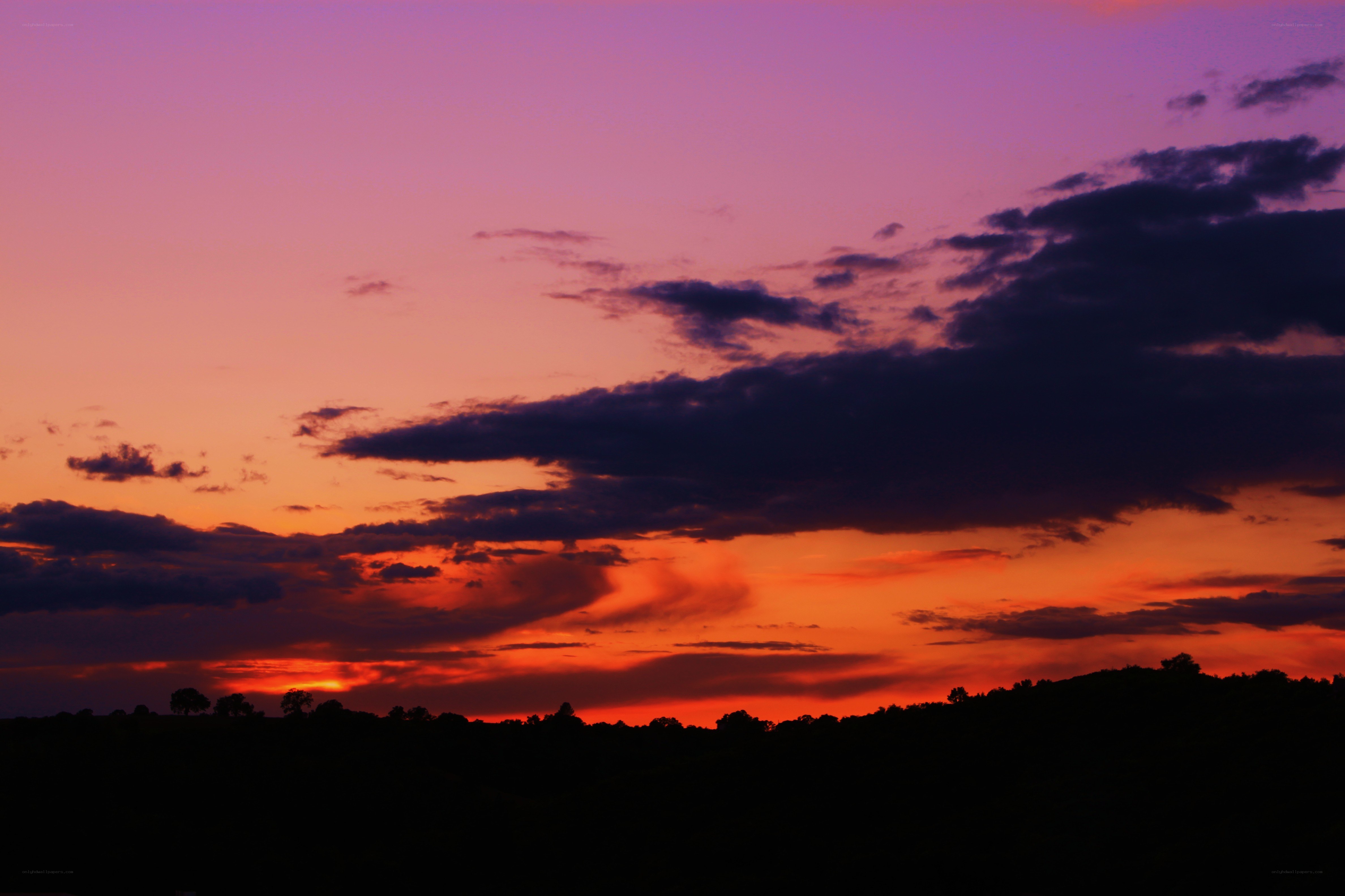 Vibrant sunset over silhouetted hills