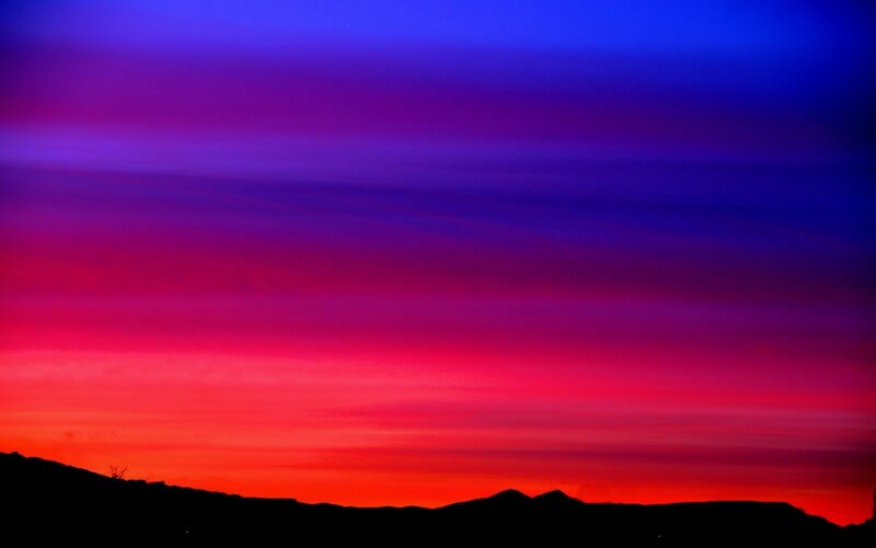 vibrant sunset over silhouetted hills