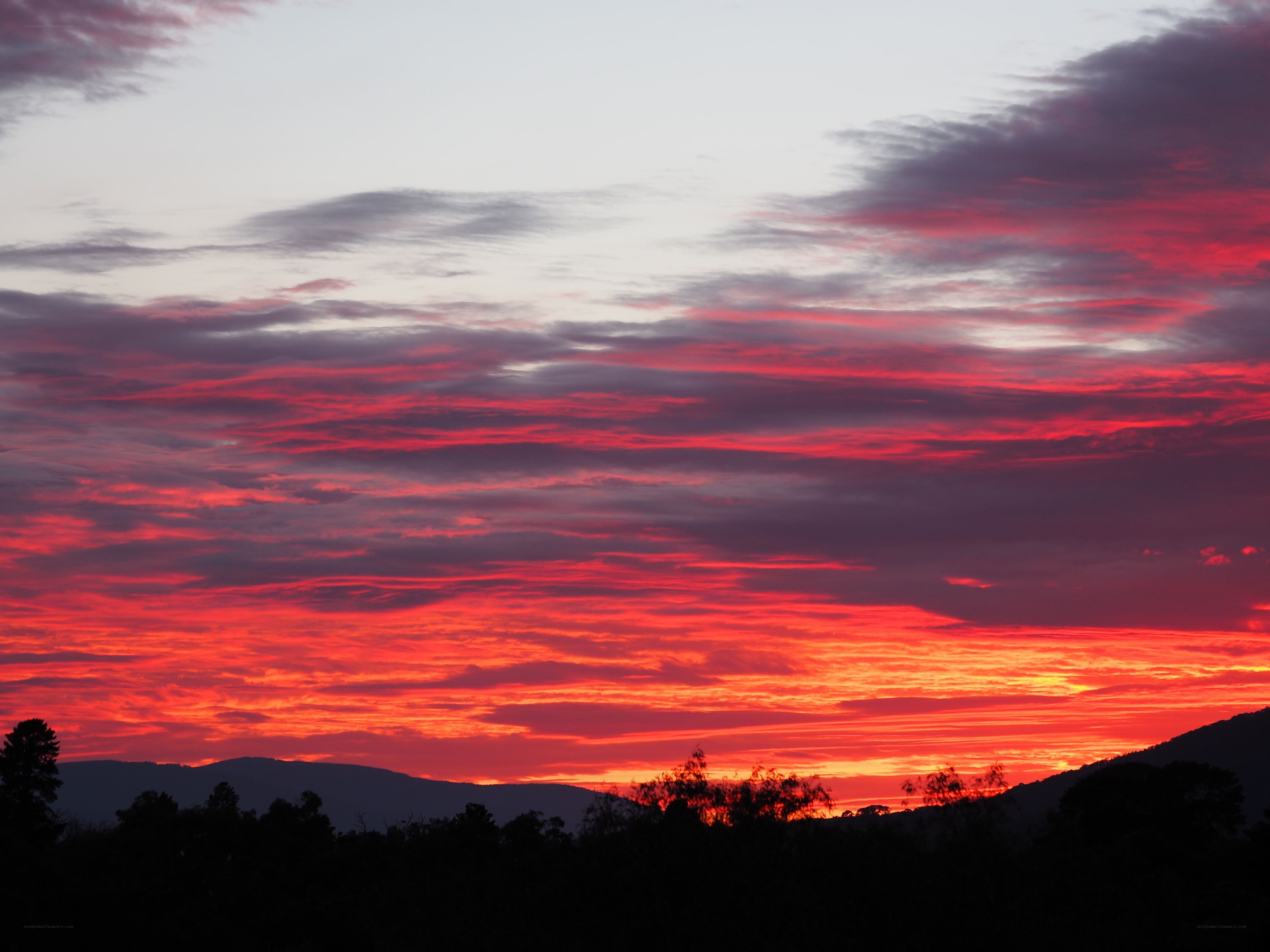 Vibrant sunset over silhouetted hills
