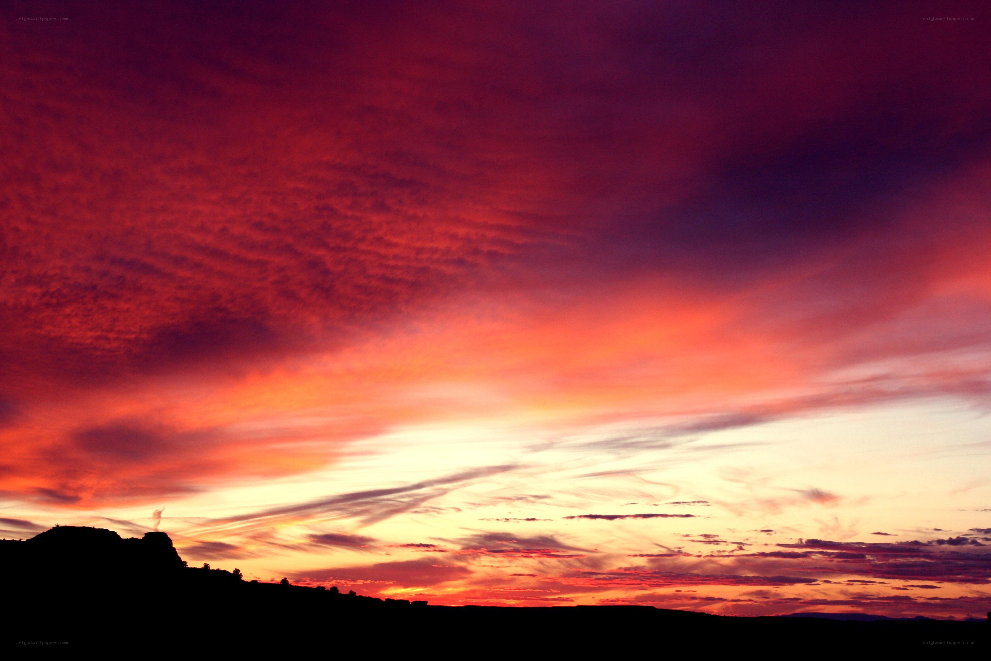 vibrant sunset over silhouetted landscape