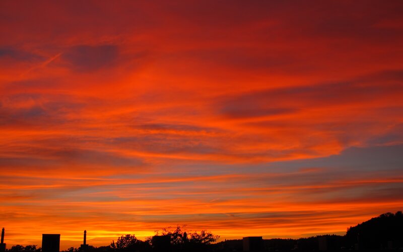 Vibrant sunset over silhouetted landscape