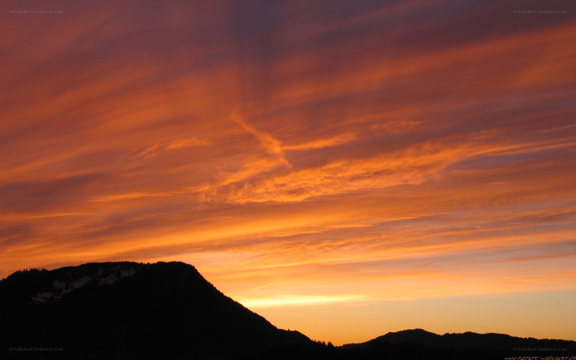 Vibrant sunset over silhouetted mountains