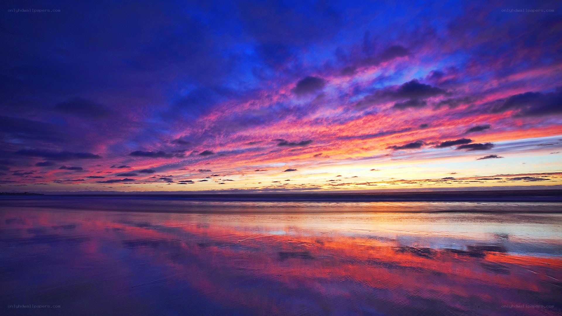 Vibrant sunset over wet beach