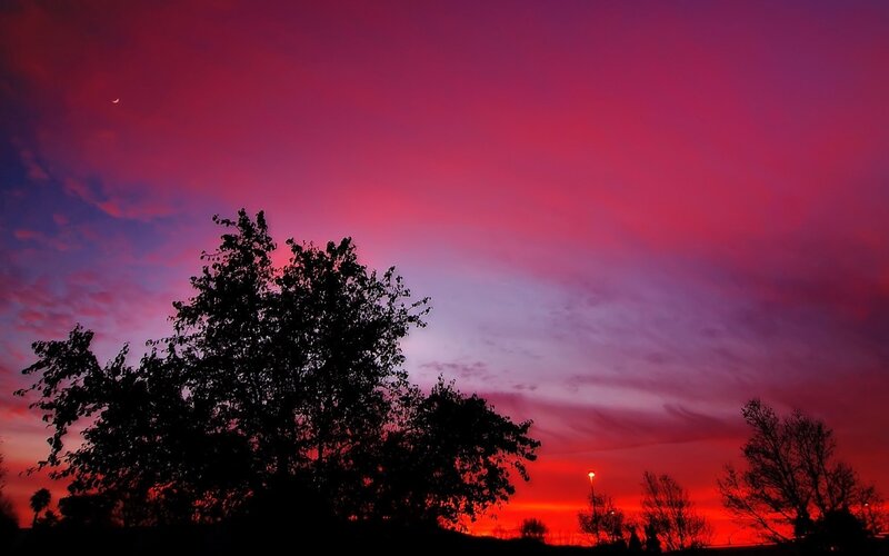 Vibrant sunset with crescent moon