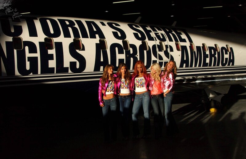 Victoria's Secret Angels in front of plane