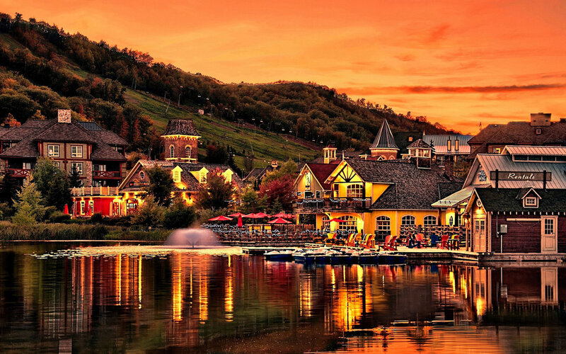 Village by Lake at Sunset — Orange, Serene, Photograph, Buildings, Fountain