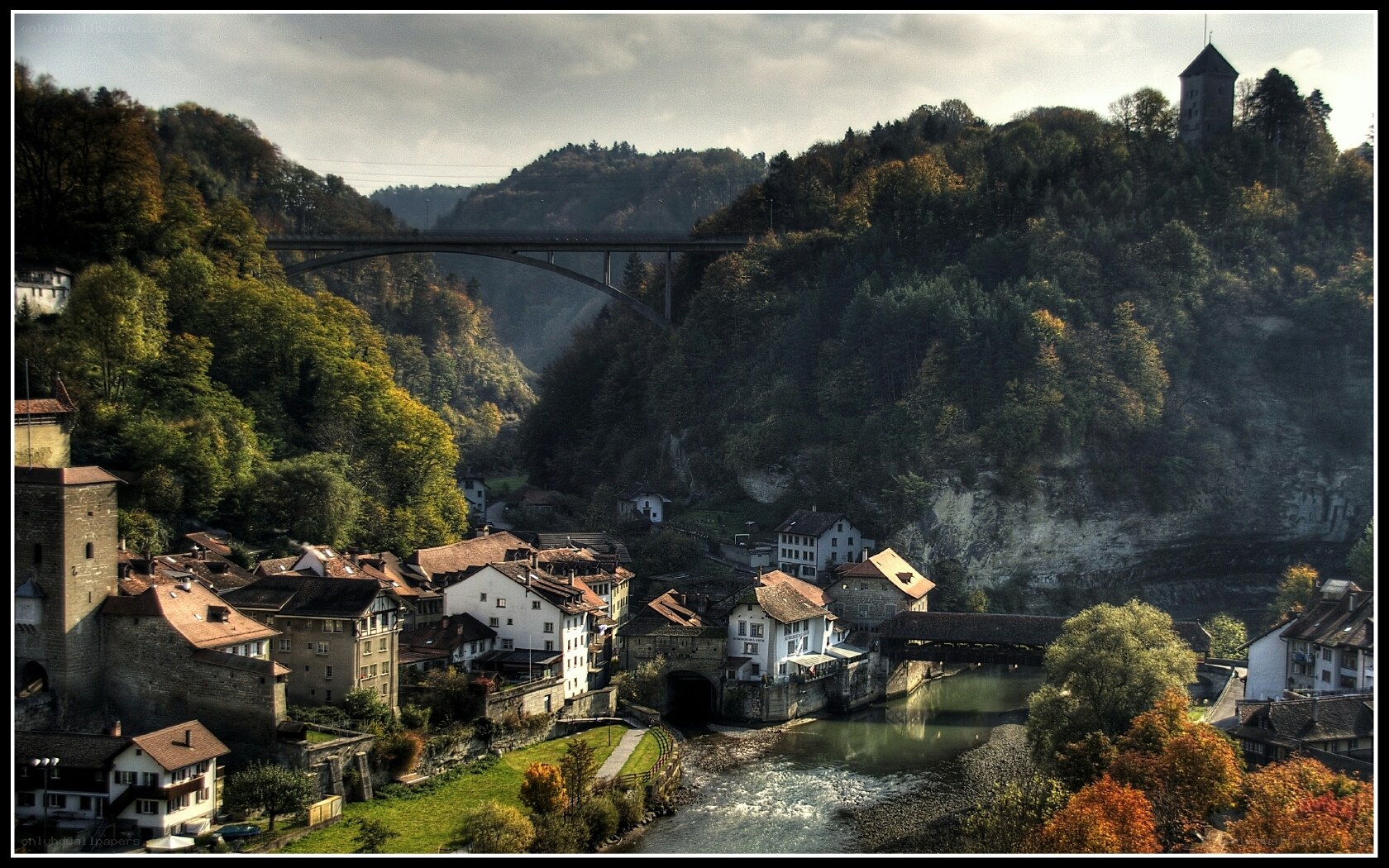 village by river with castle