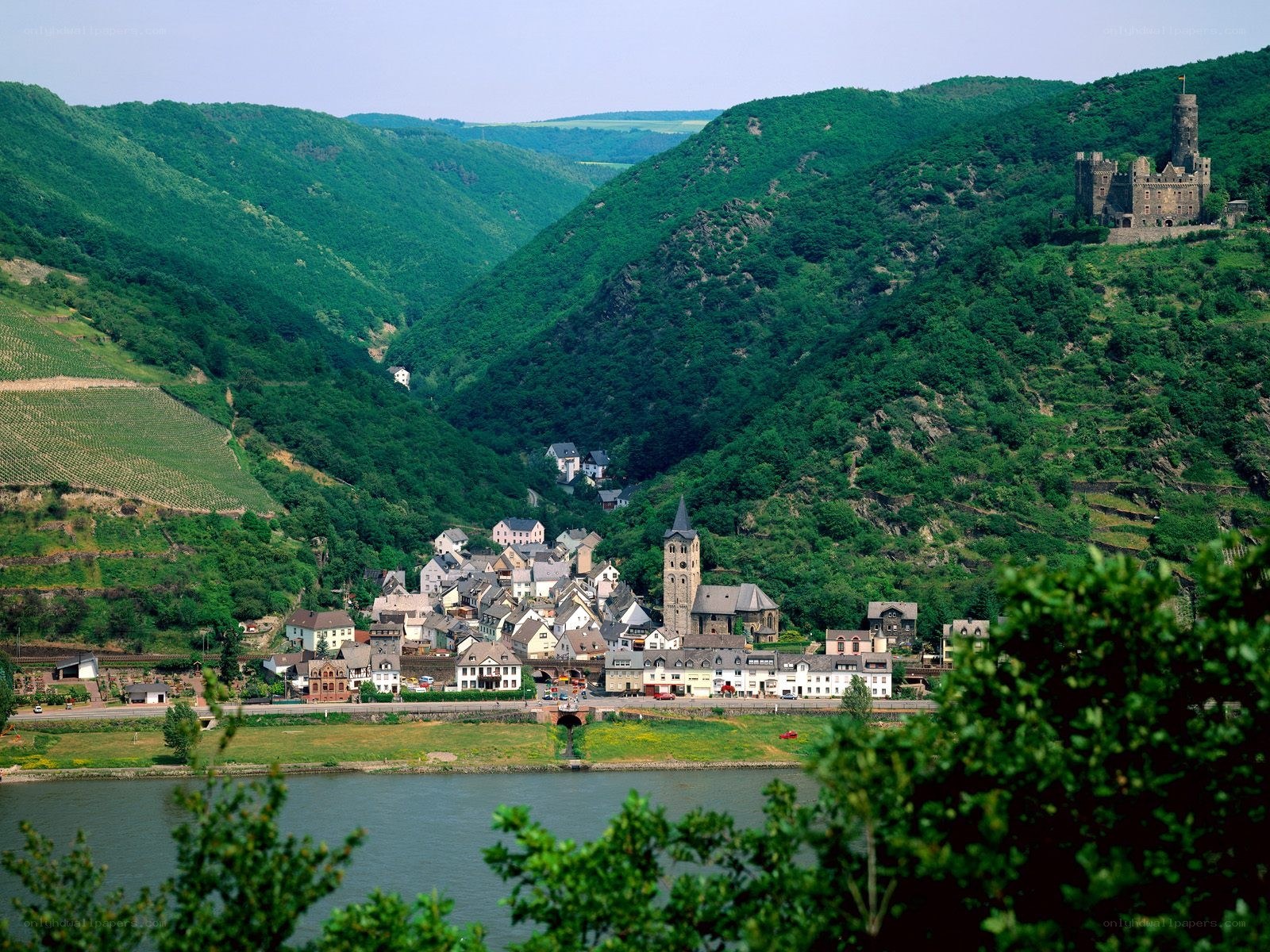 village by river with castle